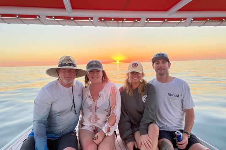 a couple of people that are sitting on a boat posing for the camera