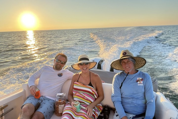 a group of people sitting next to a body of water