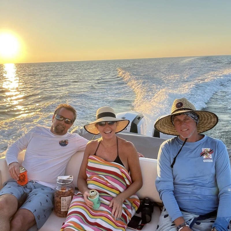 a group of people sitting next to a body of water