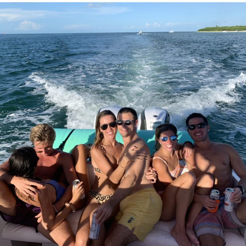 a group of people sitting next to a body of water